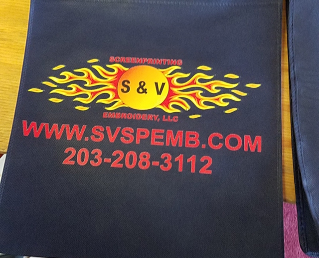 S & V flame logo printed on a navy bag